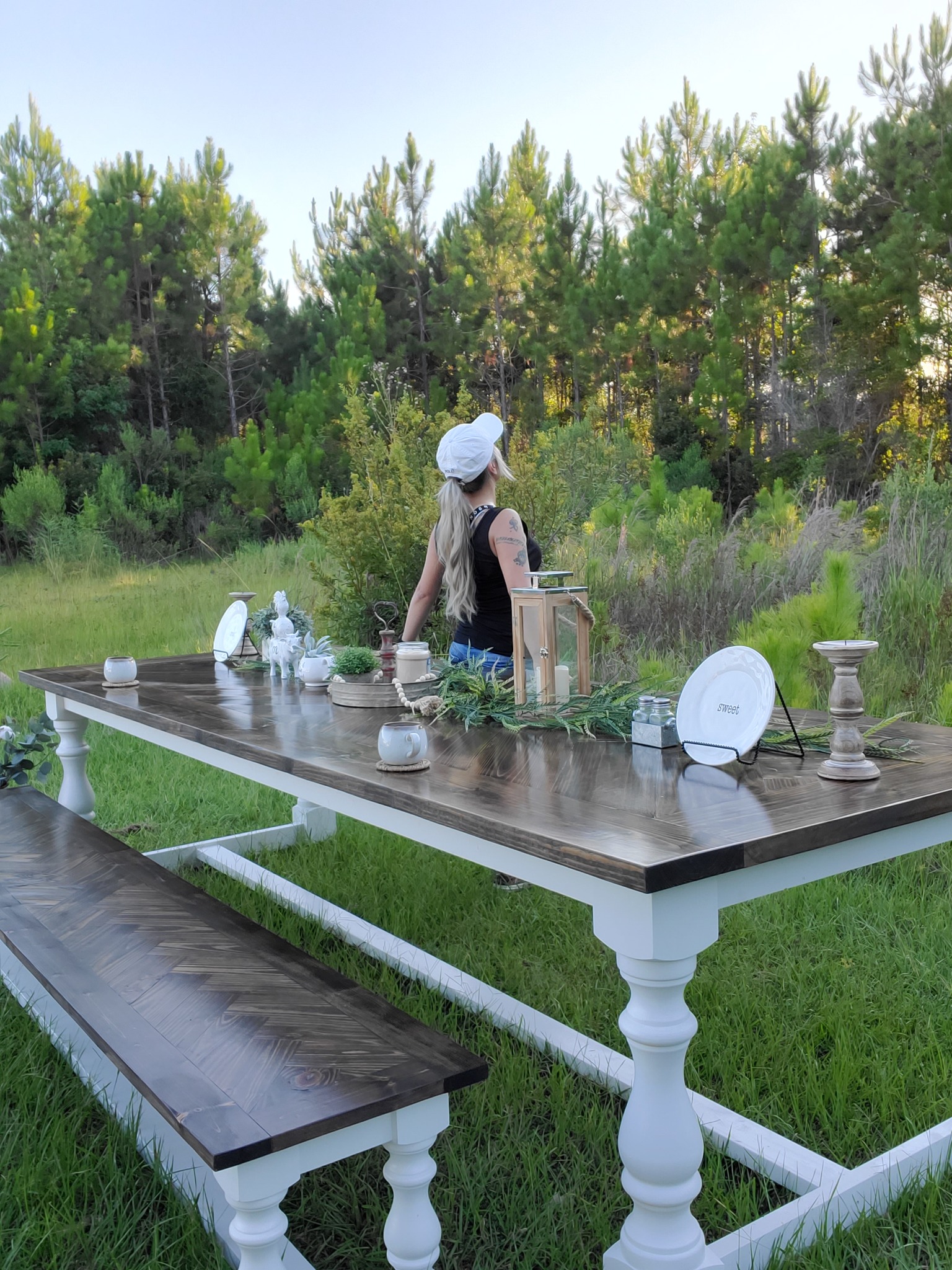 Finished dark wood farmhouse table and matching bench with white turned legs outdoors