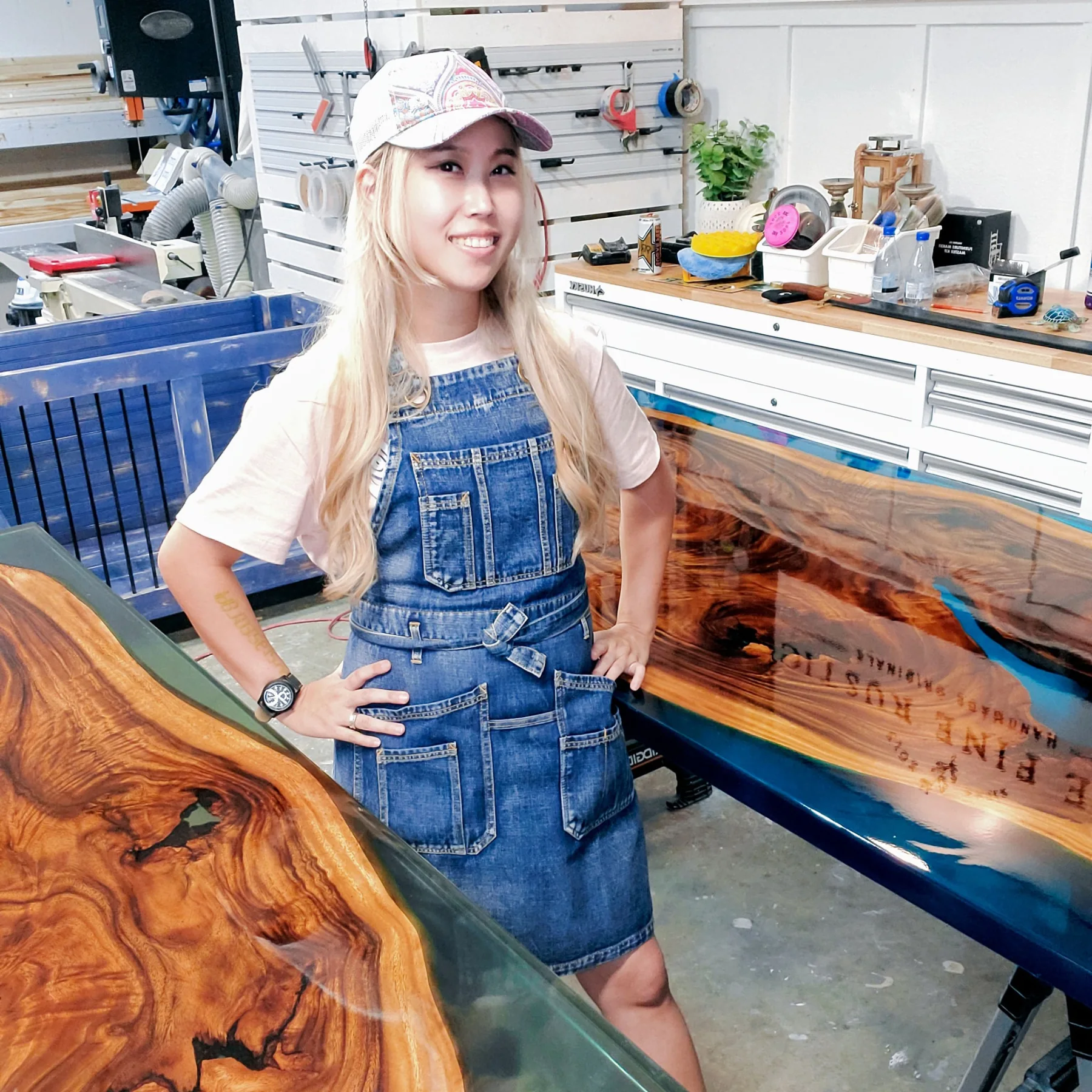 Joy in her workshop beside a handmade live edge wood table