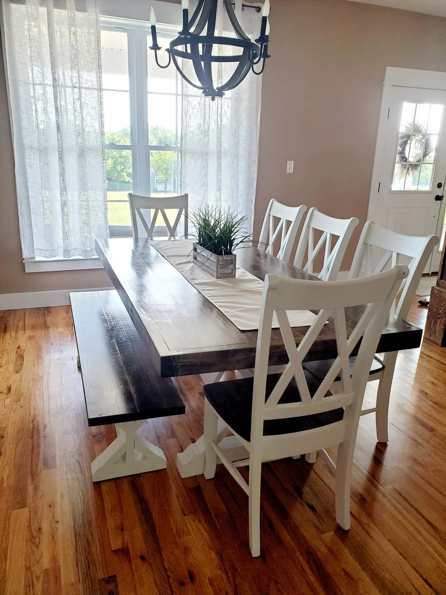 Handmade white and wood farmhouse dining table in a bright dining room
